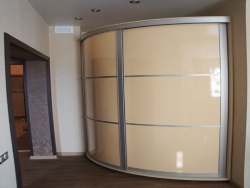 Радиусный шкаф-купе с кремовыми глянцевыми дверями